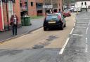 COMPLAINT: Lynn Denham near the pothole in George Street outside St Martin's Gate car park in Worcester