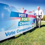 County Councillor Bob Adams with the election campaign billboard on public land next to the layby along the B4084 near Stoulton. 16476605.