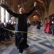 The Precentor, Canon John Paul Hoskins, crosess the line at the Worcester Cathedral pancake race