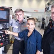 HELPING SCHOOL LEAVERS: Supervisors Kevin Parkes, left, and Colin Allcut, right, help apprentice Ali Ewida to programme one of the latest machine tools at Yamazaki Mazak’s headquarters in Worcester