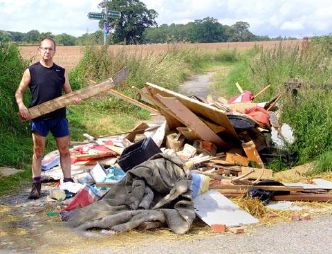 DUMPED: Andrew Brown with fly-tipped rubbish he found on a track off Oldbury Road
