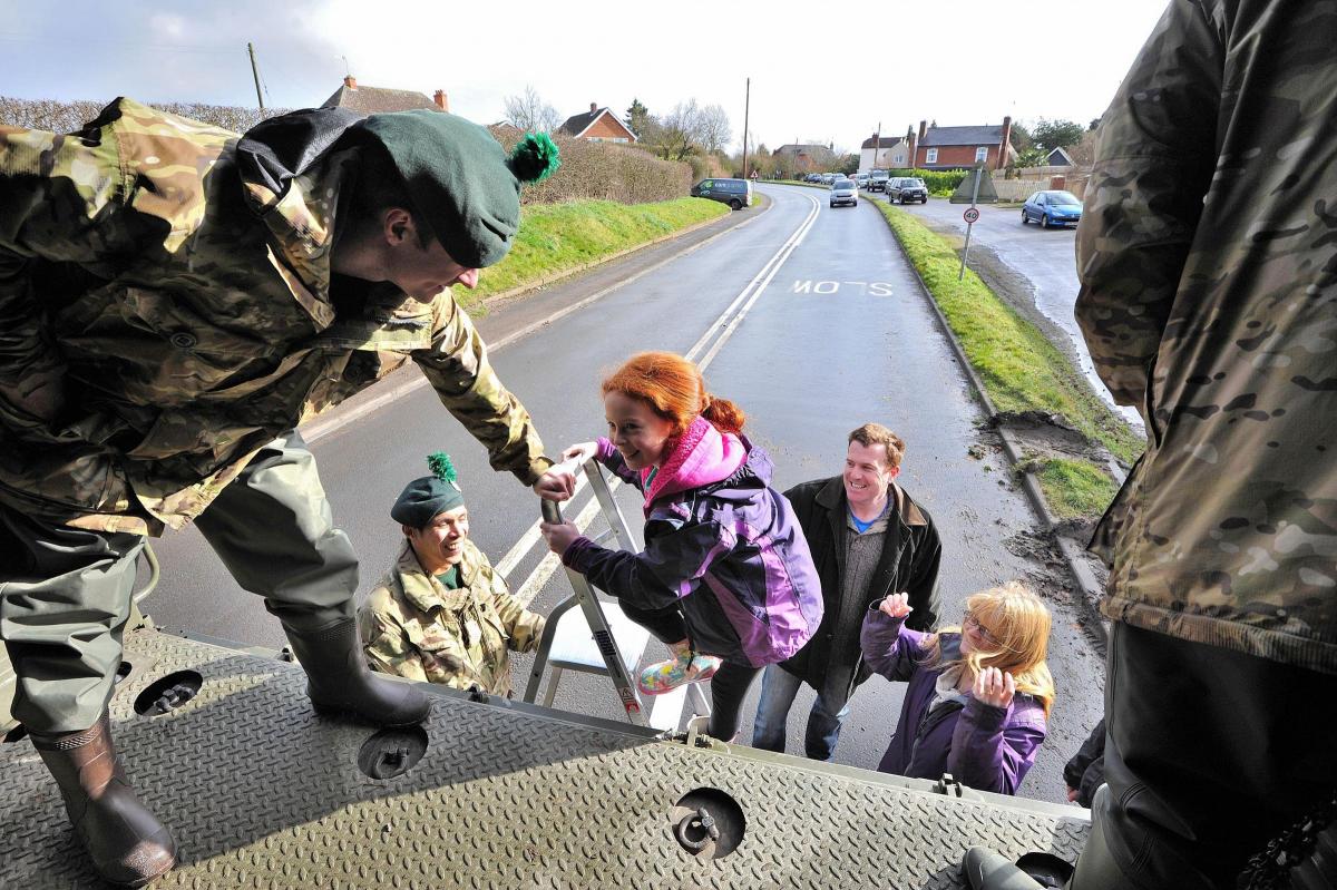  Members of the Royal Irish Regiment use their MAN trucks to ferry members of the public to and from Upton town centre from over the flooded bridge at Ryall on Saturday. 0614522504