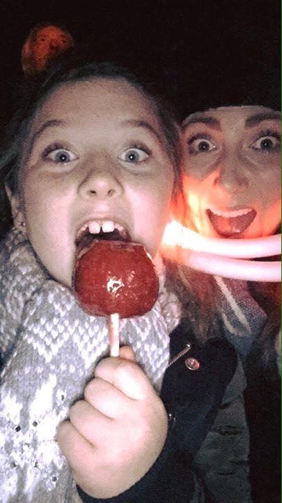 Imogen Cottrell enjoys a toffee apple at the King's Hawford School bonfire event with Gemma Woolley. Picture by Sarah Cottrell.