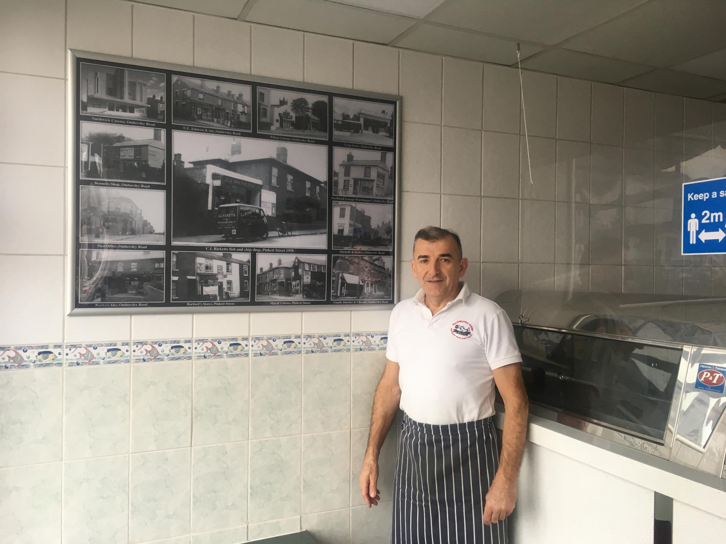 The Crispy Cod owner Predrag Djuric with a display inside his shop of old photos of local businesses