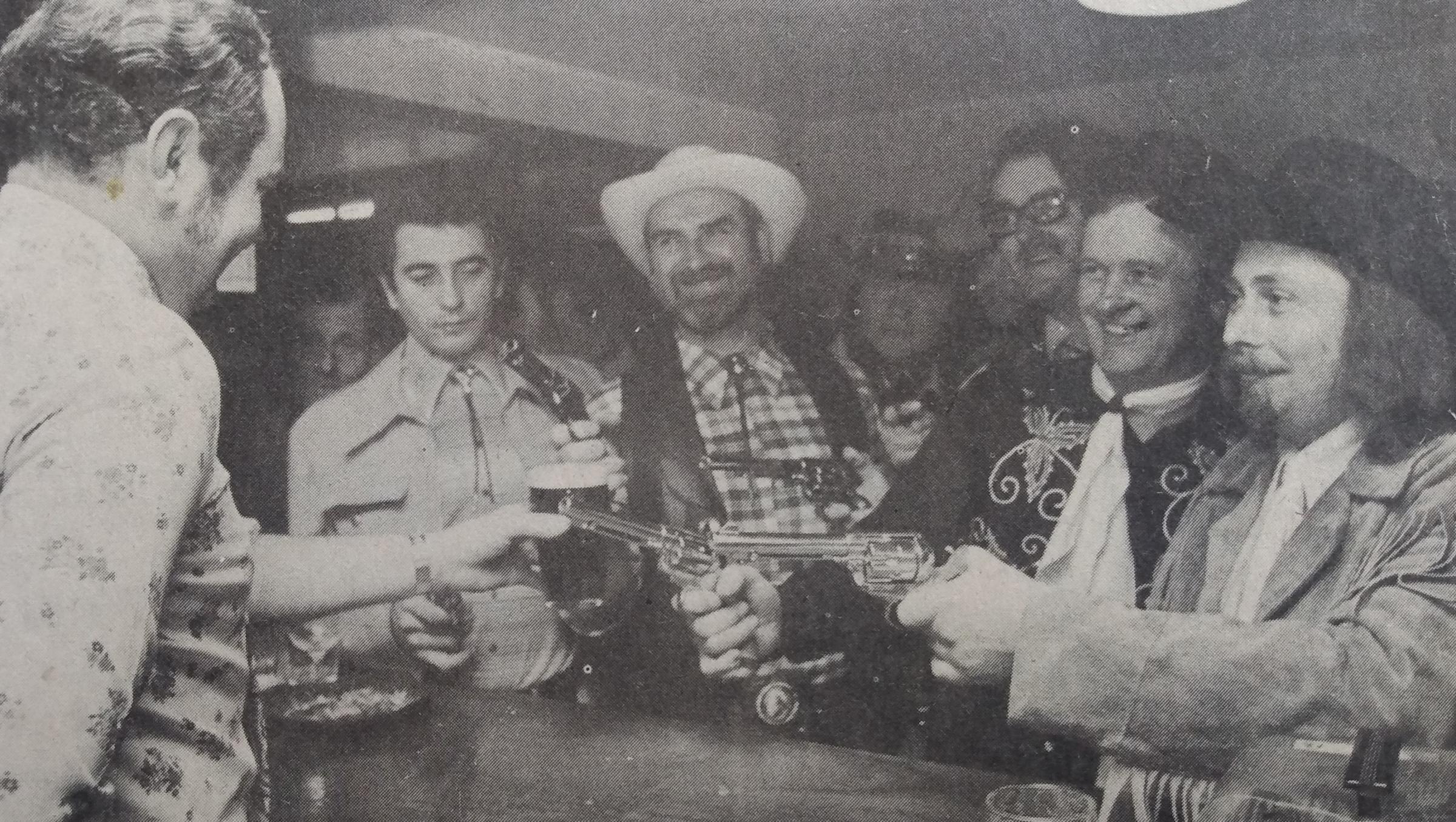 Barman Tony Hill is held up by gun-toting regulars who were members of Diamond Lils Country and Western Club at the Goodrest Inn. The picture was taken in December 1976