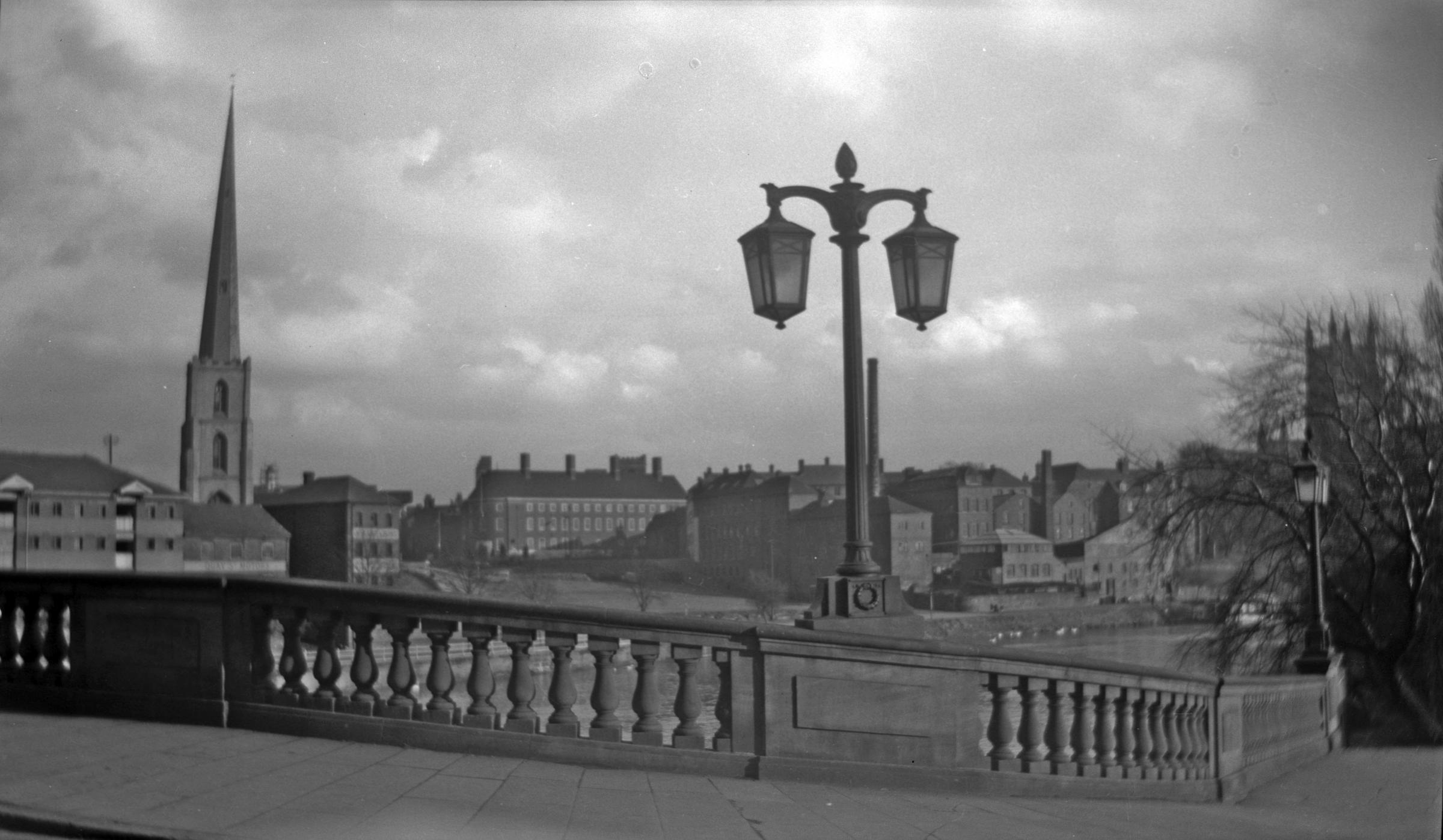 Worcester Bridge in the 1950s, complete with Hardy and Padmore Lamp Standards. In the background can be seen the former Dents Glove Factory premises, on the bank of the Severn
