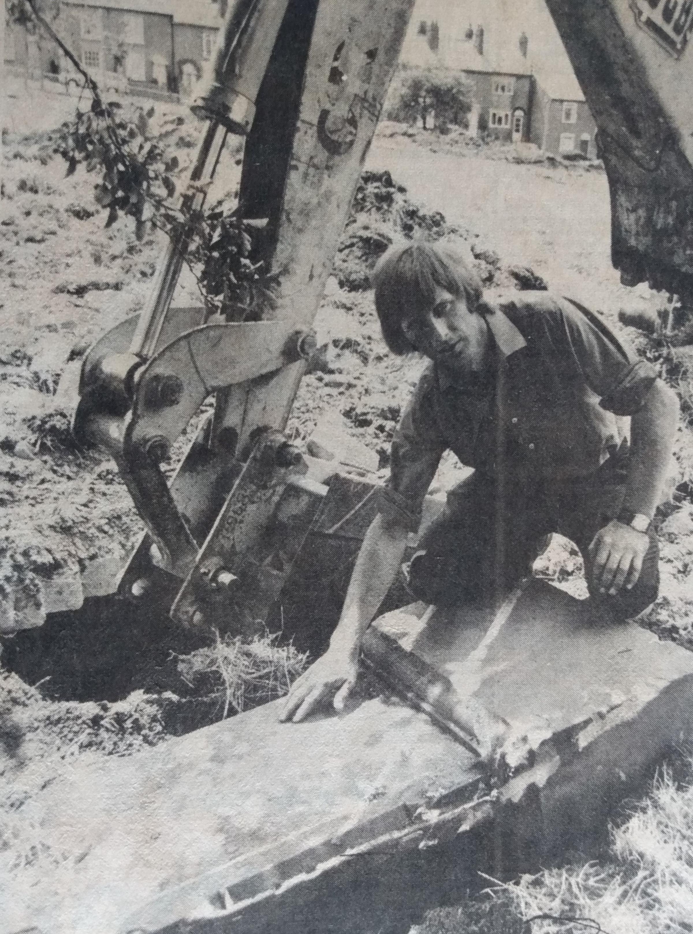 July 1976 and mechanical digger driver Lawson Wall is pictured with a tombstone he accidentally unearthed while levelling a children’s play area