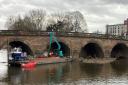 REMOVAL: A crane operated by the Canal and River Trust scoops up debris caught against Worcester Bridge