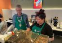 Store manager Leah Jones shows mayor Louis Stephen how to make a latte