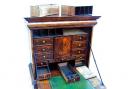 A number of secret drawers were found in this 18th century walnut cabinet, left.
