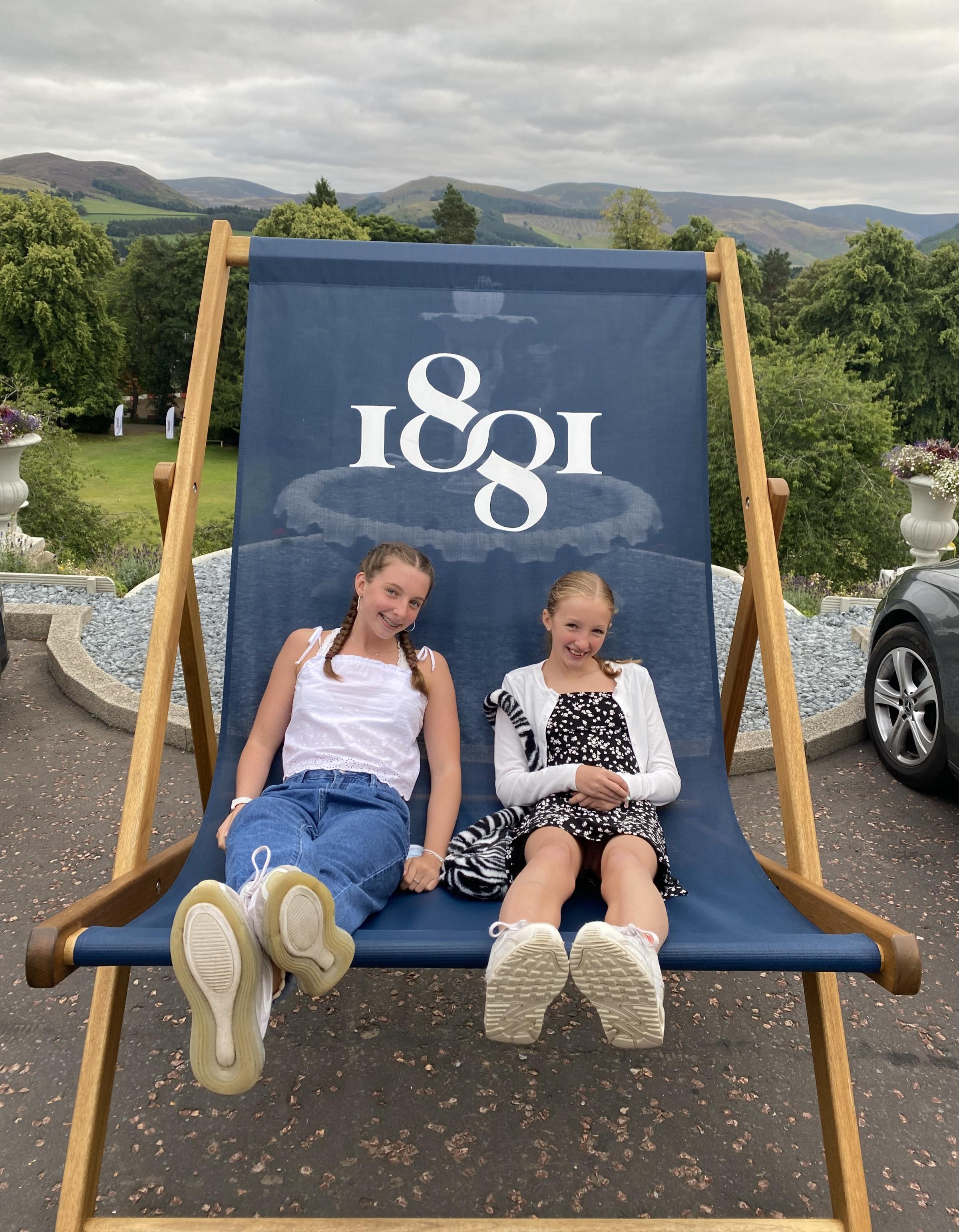 Isla and Evelyn in an outsize deckchair bearing the logo of the world-famous 1881 gin – every drop of which is taken from the hotel’s private spring, Shieldgreen