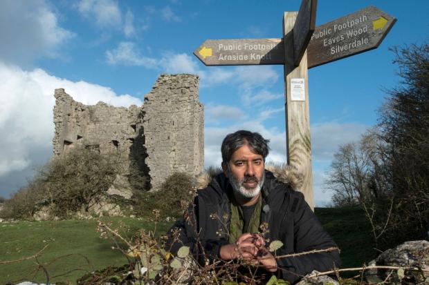 Worcester News: Nihal Arthanayake under a footpath sign next to Arnside Tower. Photo credit: BBC.