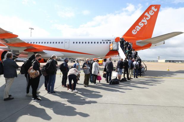 Worcester News: People queue to board an EasyJet plane. (PA)