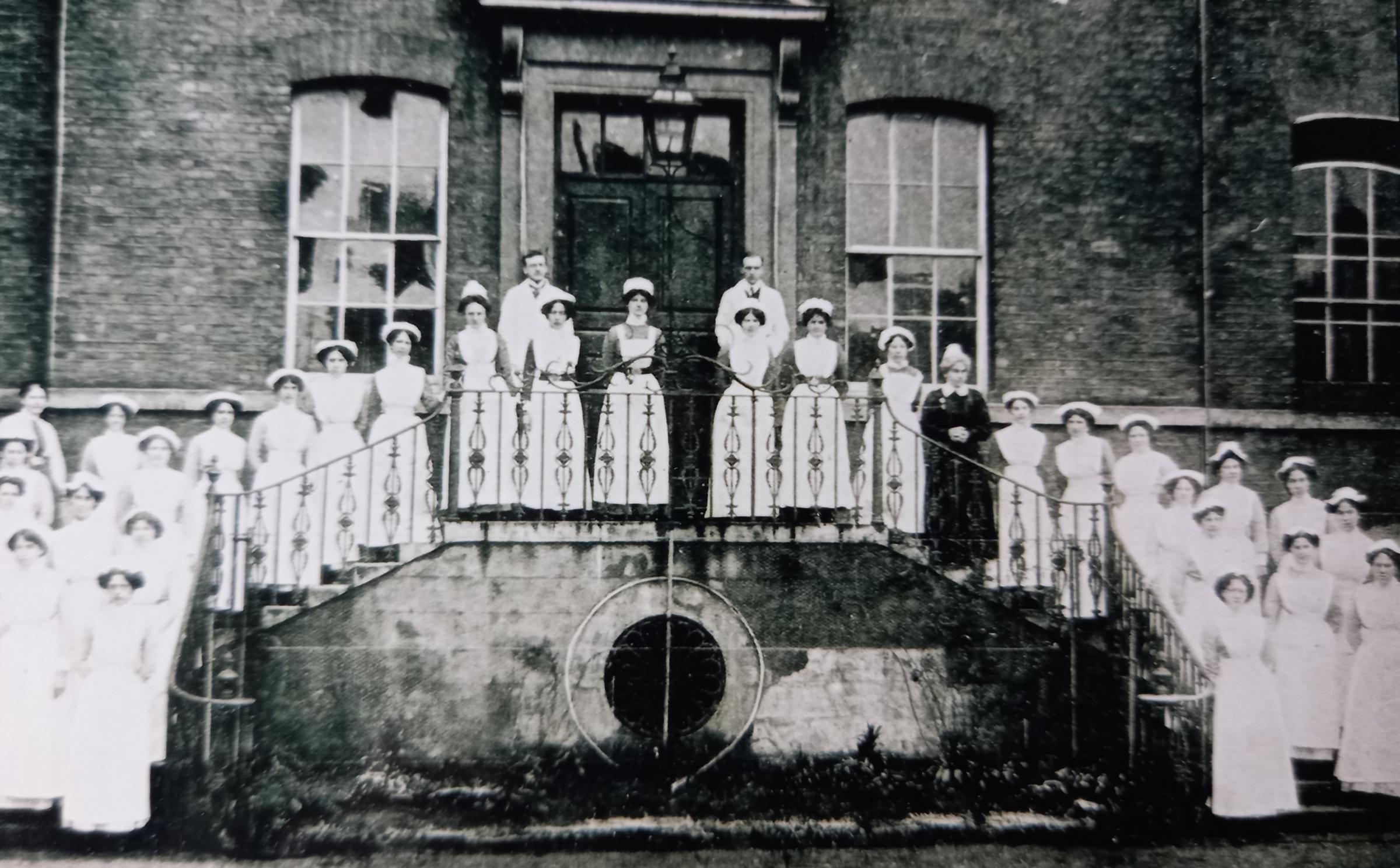 Fine undated old photo of nursing staff on the steps of the hospital entrance off Infirmary Walk
