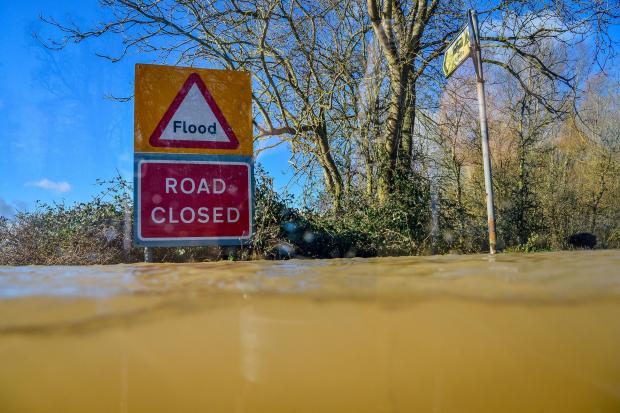 A road closed sign and floodwater