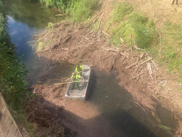 Worcester News: DEDICATED: Environment Agency officials had their hands full clearing the blockage from the River Teme. They are pictured here from the top of the Powick Old Bridge. Photo: James Connell