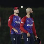 England's Liam Livingstone, left, tosses the ball as he walks with teammate Moeen Ali during the Cricket Twenty20 World Cup warm-up match between India and England in Dubai, UAE, Monday, Oct. 18, 2021. (AP Photo/Aijaz Rahi).