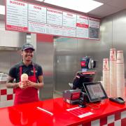 George Hinds, manager of Five guys in Worcester, holding the new pigs in blankets milkshake.
