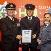 Josh Szikora-Warmington (centre) receives his certificate of commendation from Chief Fire Officer Jon Pryce (left) and chairman of Hereford & Worcester Fire Authority Councillor Kit Taylor