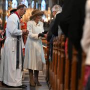 GIFT: Queen Camilla, deputising for the King, distributes the Maundy money - newly minted coins - to community stalwarts in recognition of their service, during the Royal Maundy Service at Worcester Cathedral.