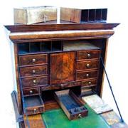 A number of secret drawers were found in this 18th century walnut cabinet, left.