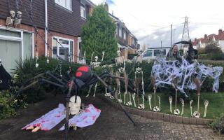 Ross Hayes decorated his front lawn with an assembly of skeletons, broomsticks and witches, which were topped off by a giant spider crouched over a pair of covered-up corpses